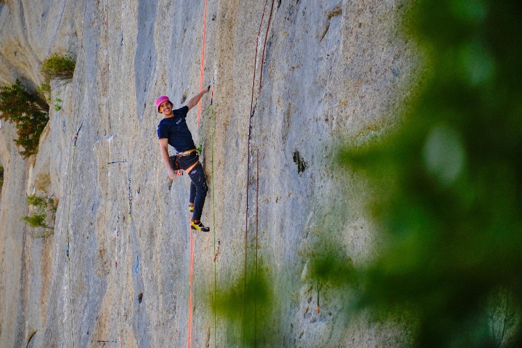 Grimpeuse en pleine ascension sur un mur de bloc coloré